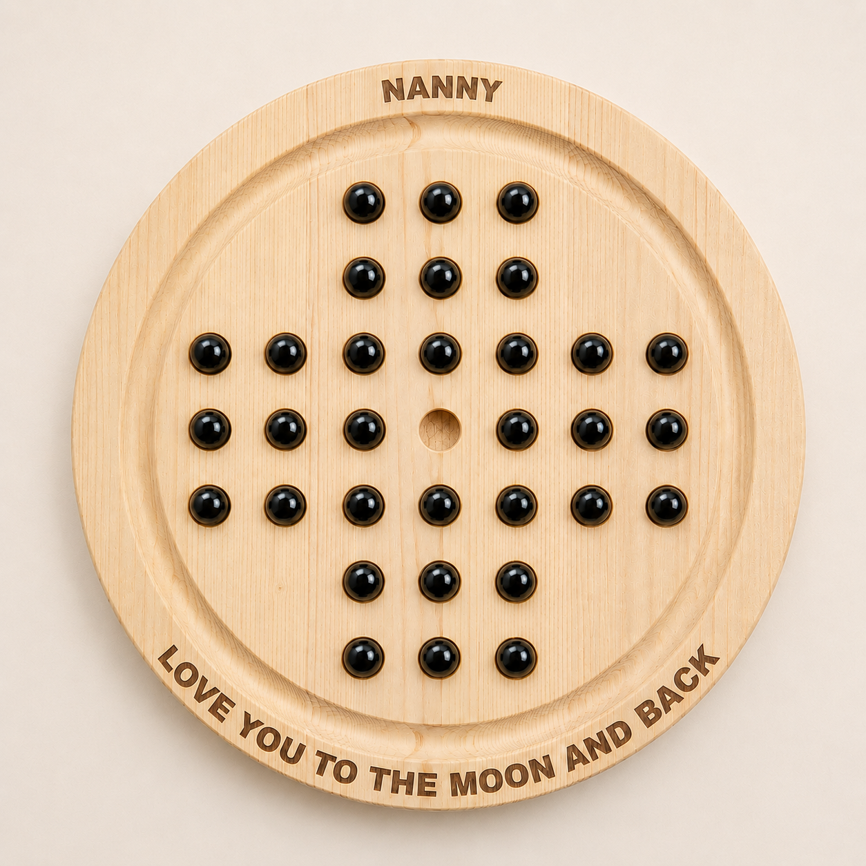 Personalised wooden solitaire board game top-down view with black marbles